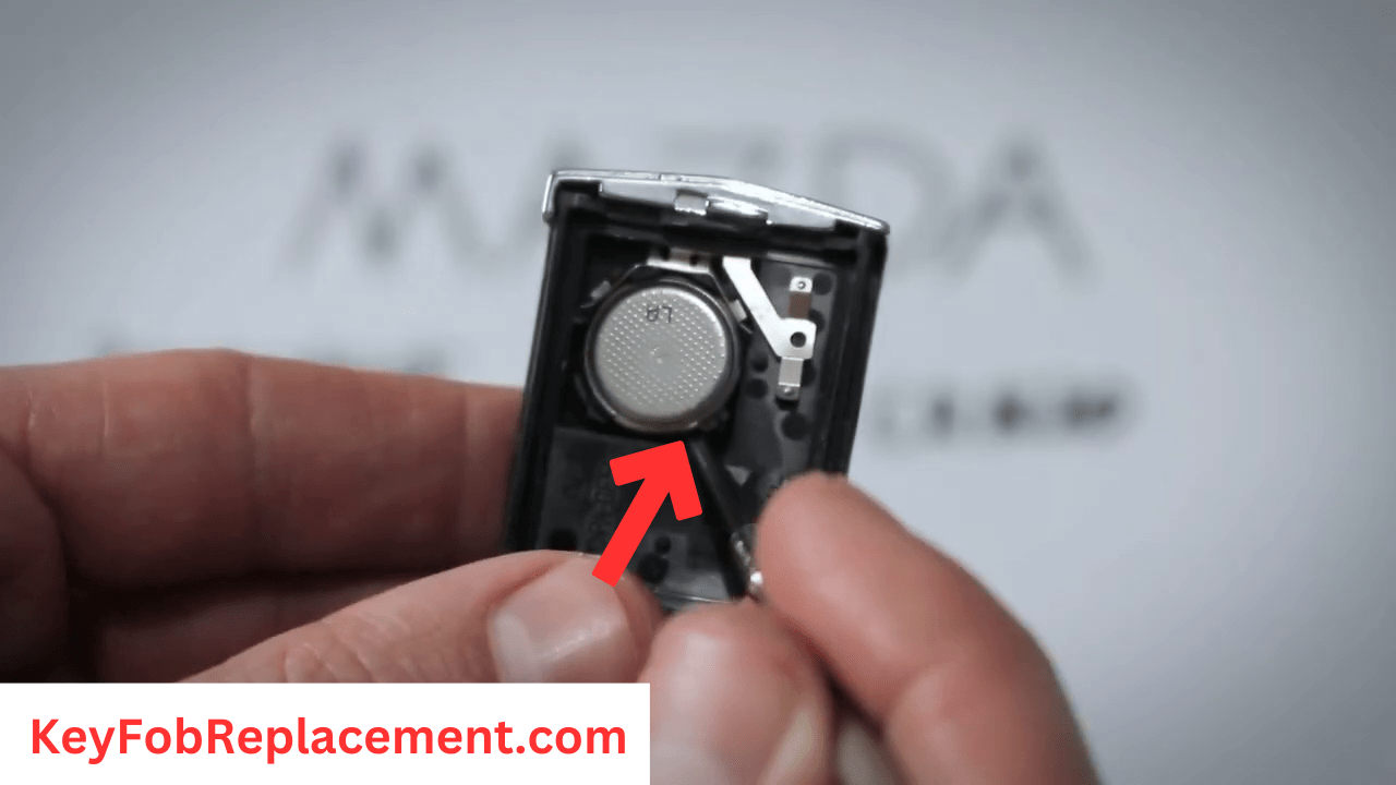 Mazda 5 Flip 3-Button Key Use thin tool to remove battery with black arrow